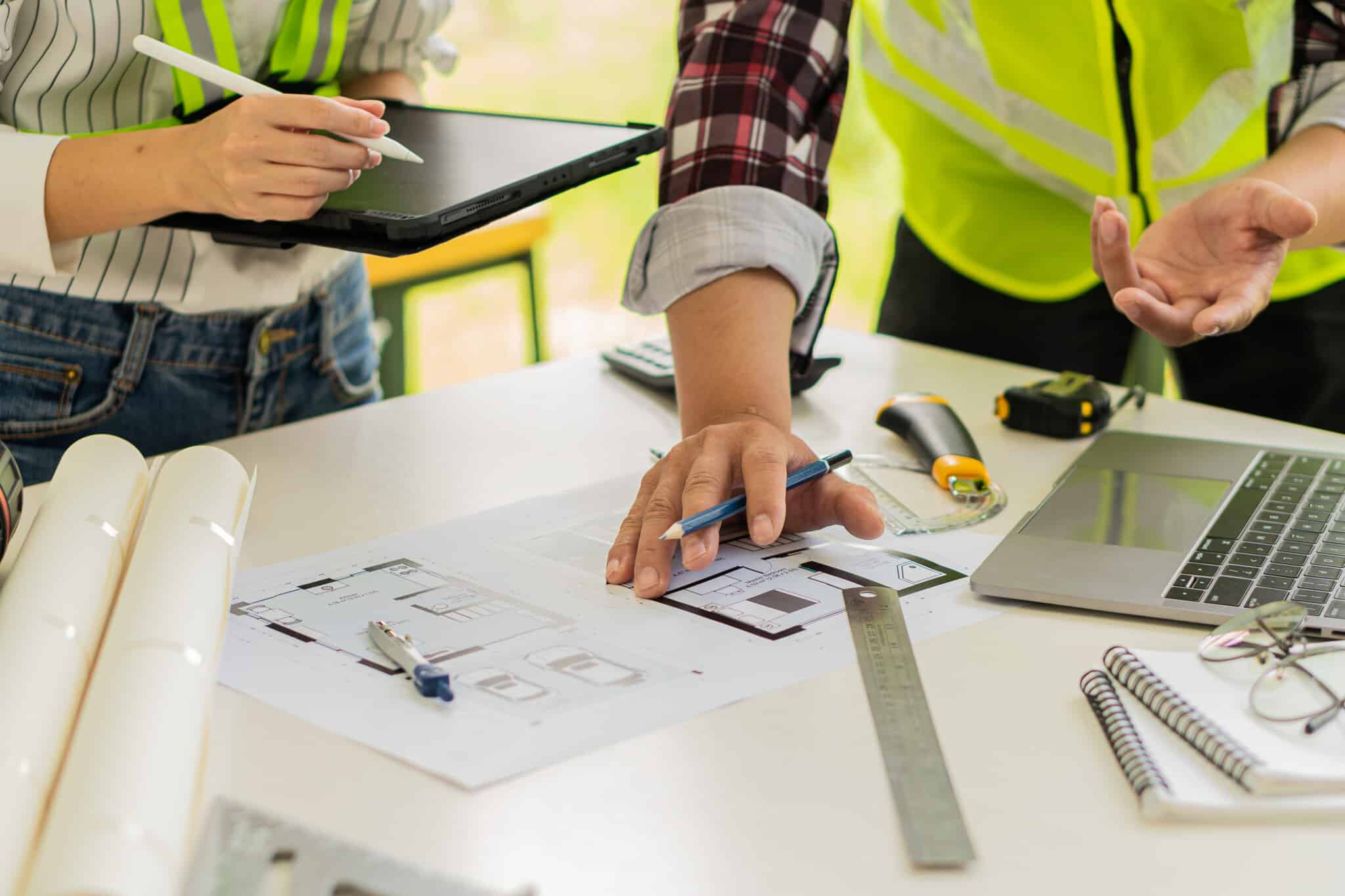 All About Electrical electricians creating electrical plans with laptop, tablet, and drawings.
