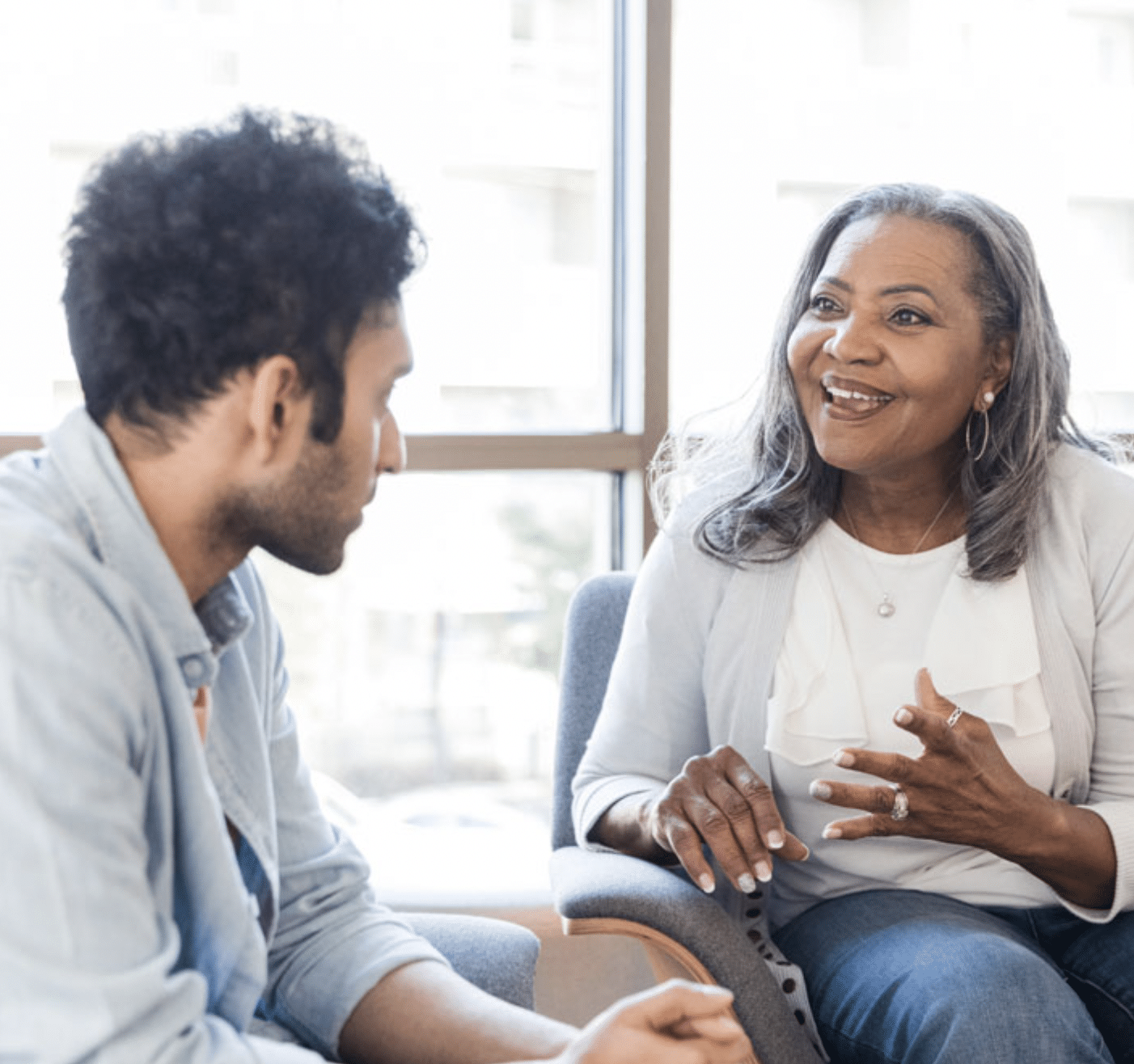Two people sit in an office talking about educational goals.