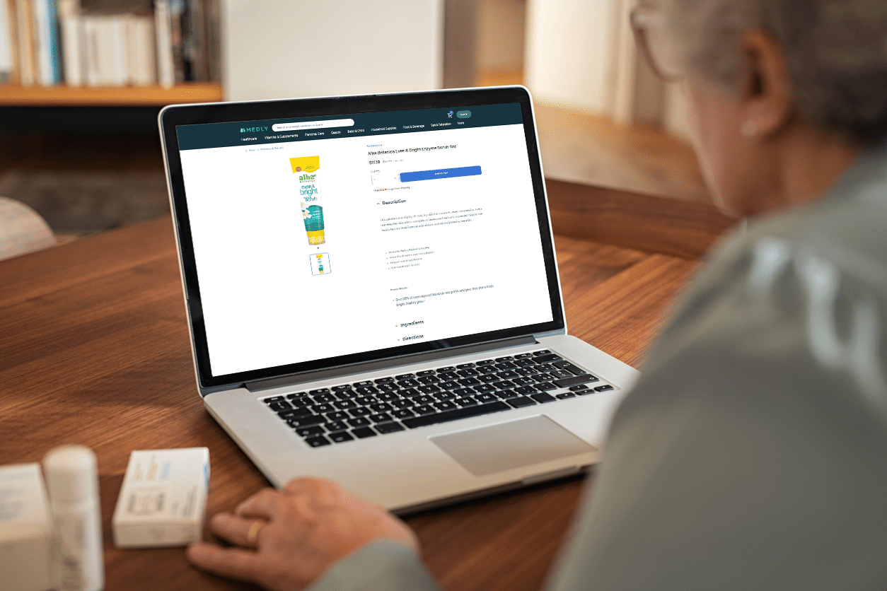 Person sits at a table with an open laptop shopping the Medly website.