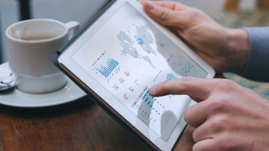 Person holds a tablet reviewing website data and metric insights.