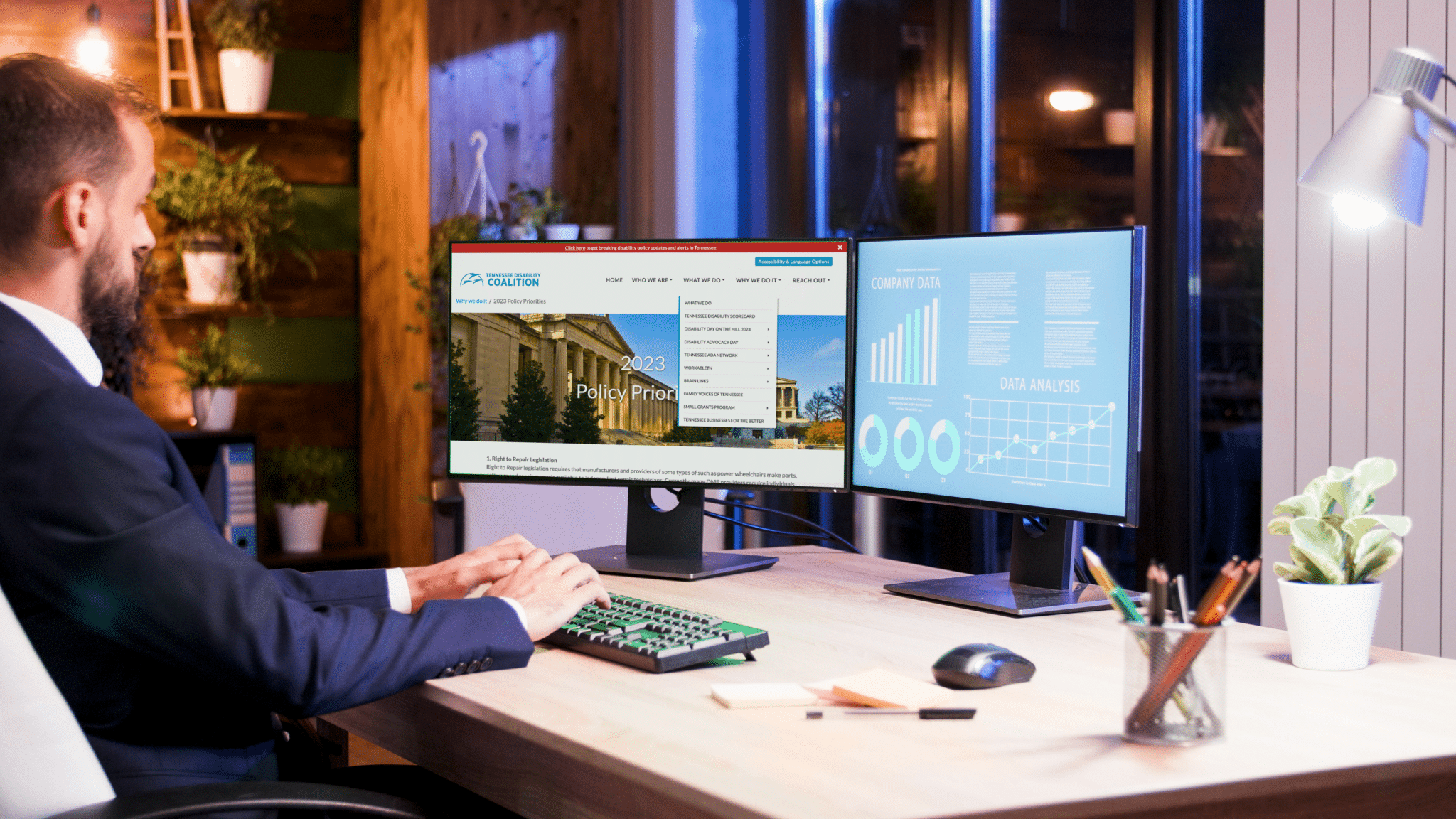 Person sits at a desk with two monitors. One displays the TNDIS homepage and the others the companies data.