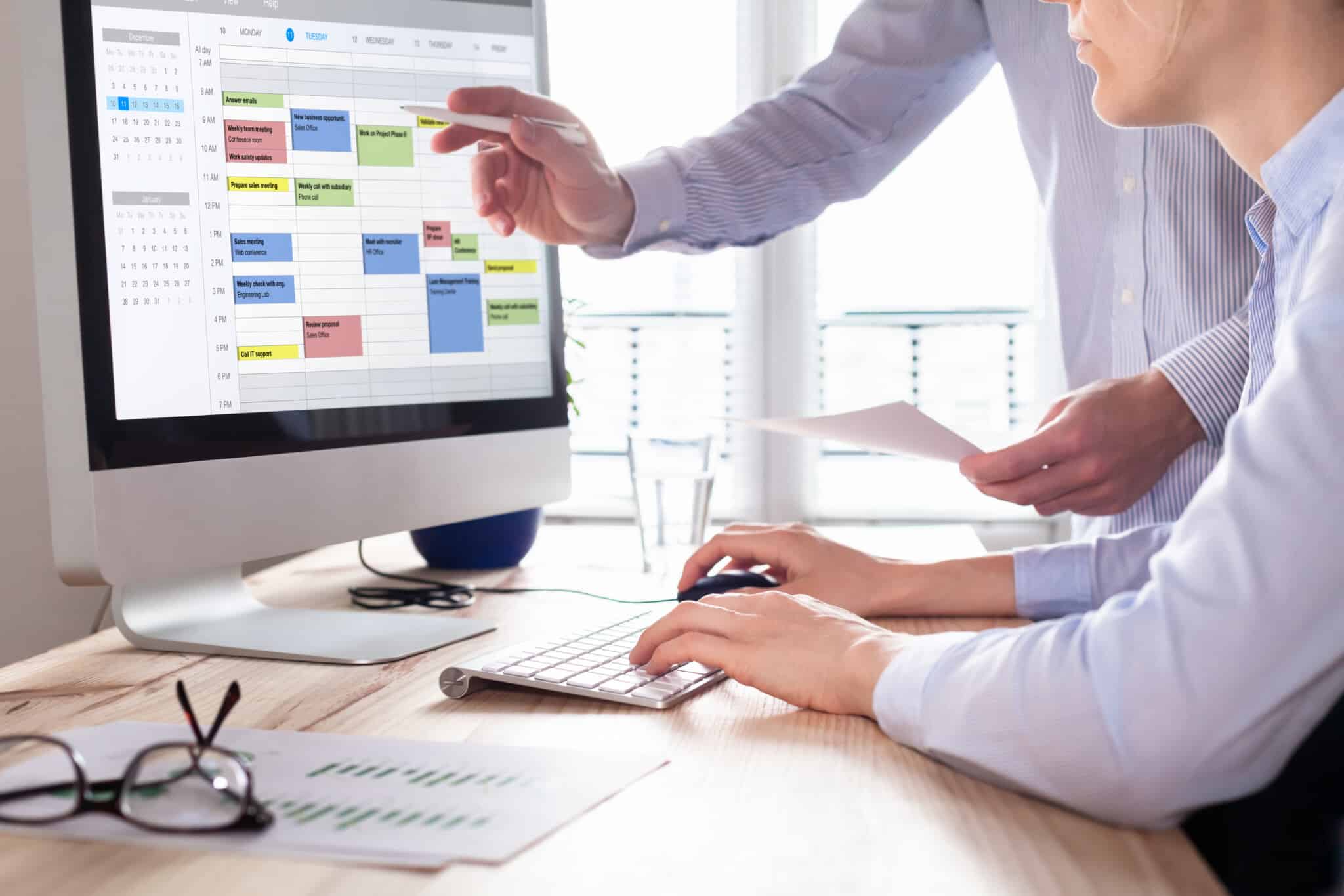 Integrated calendar used by two people on a desktop computer to schedule productivity.