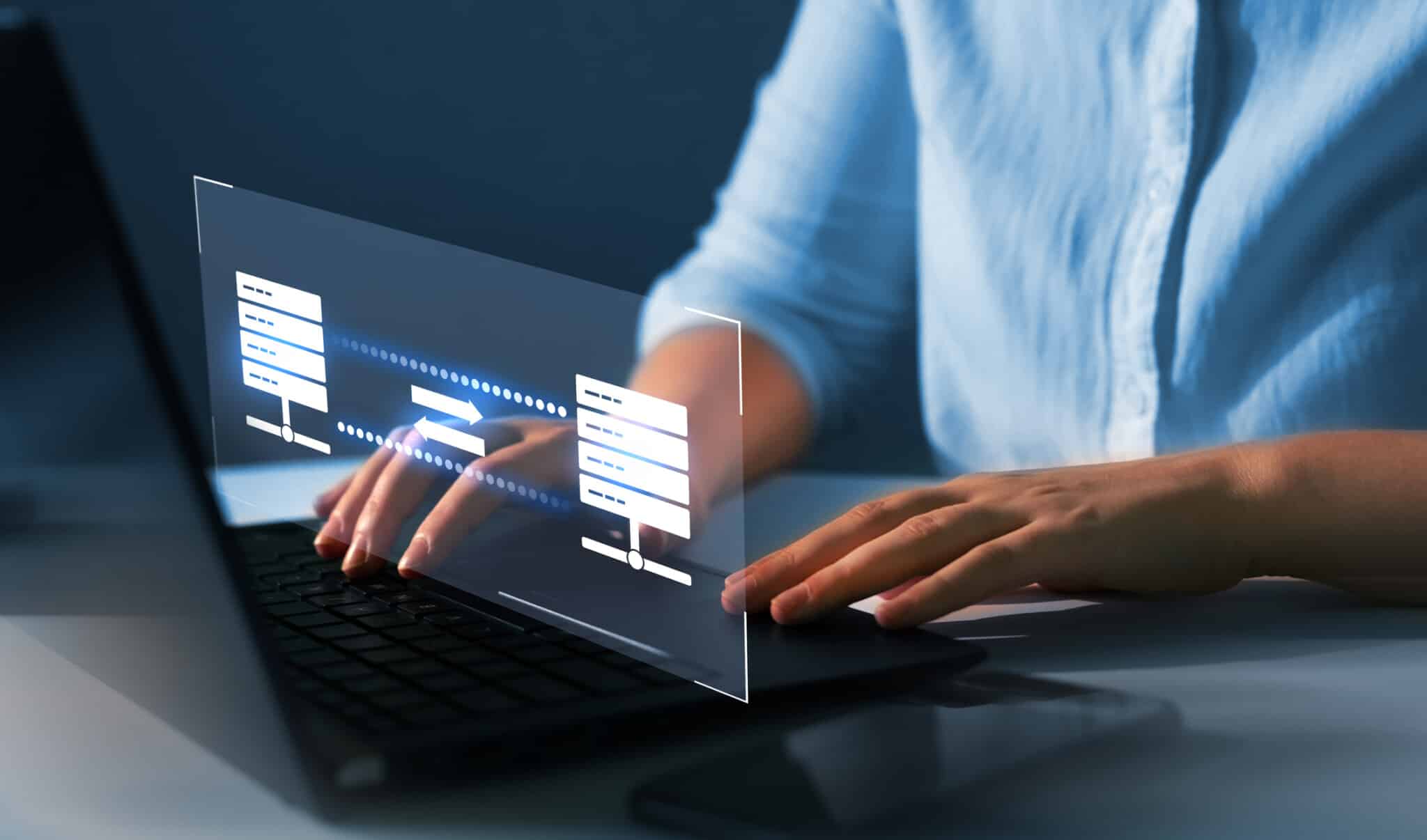 Person sits with laptop with holograph screen representing eCommerce hosting and security.