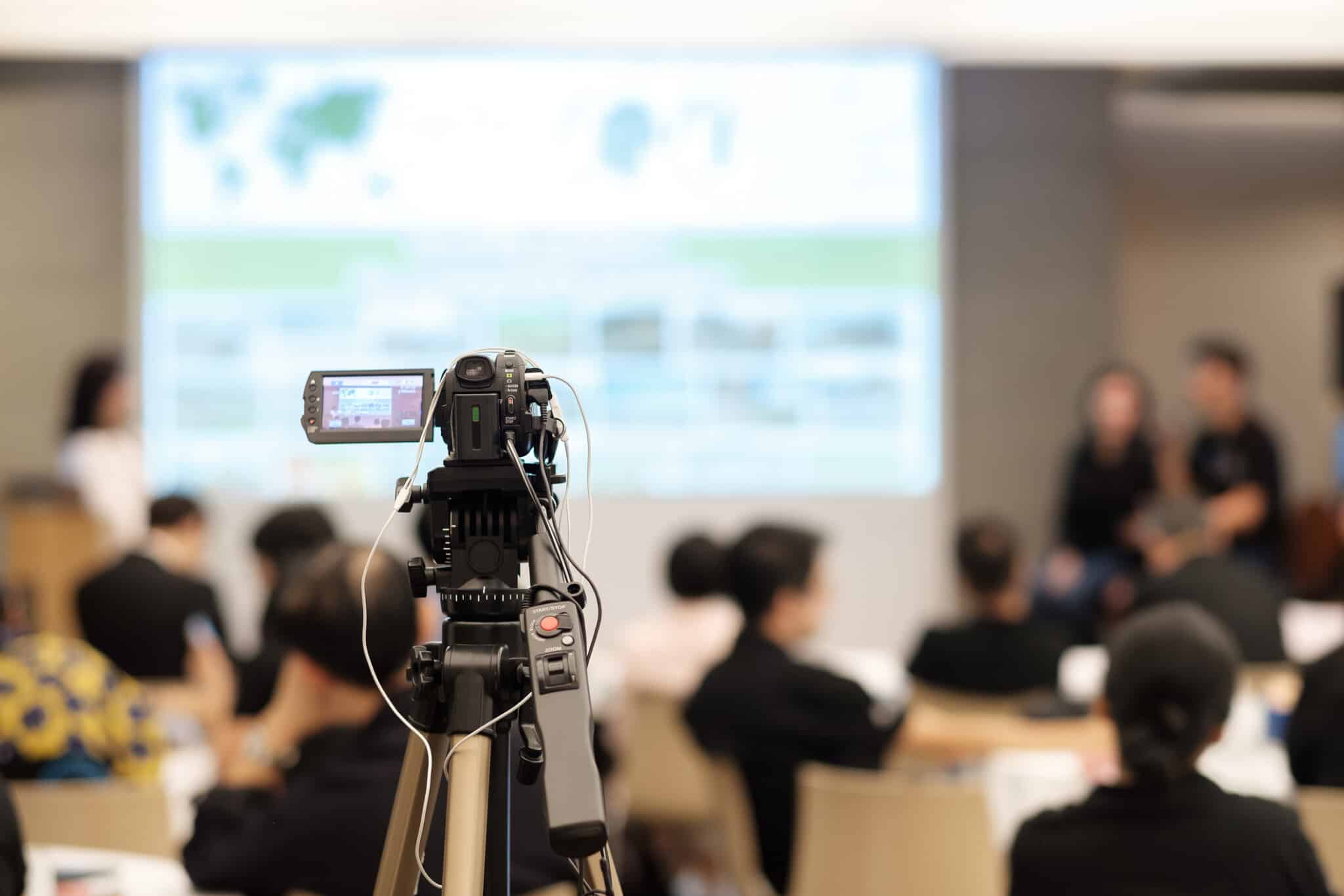 Camera on tripod records educational class presentation to upload to school website.