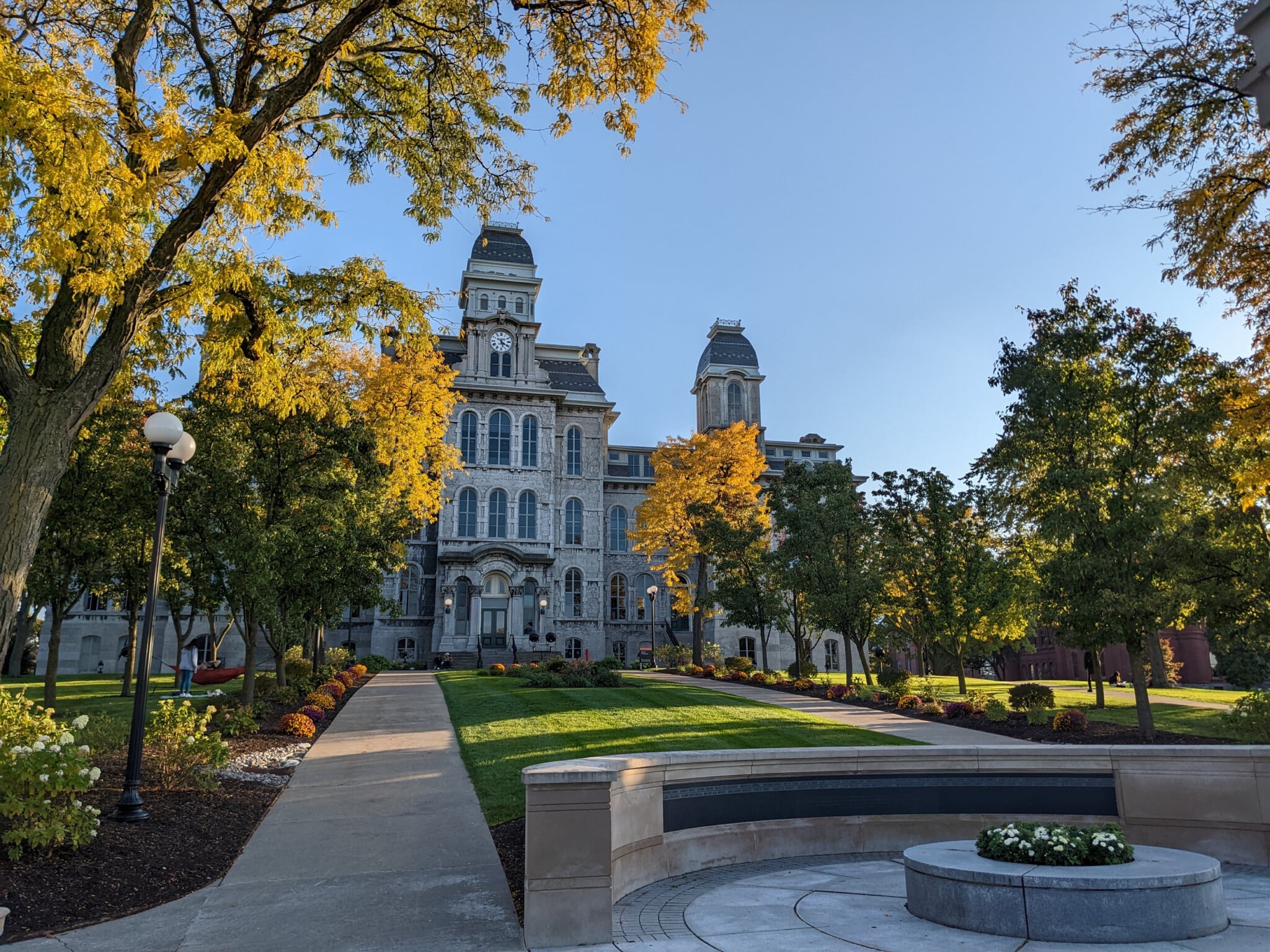 Syracuse University building sits behind landscaped entry.