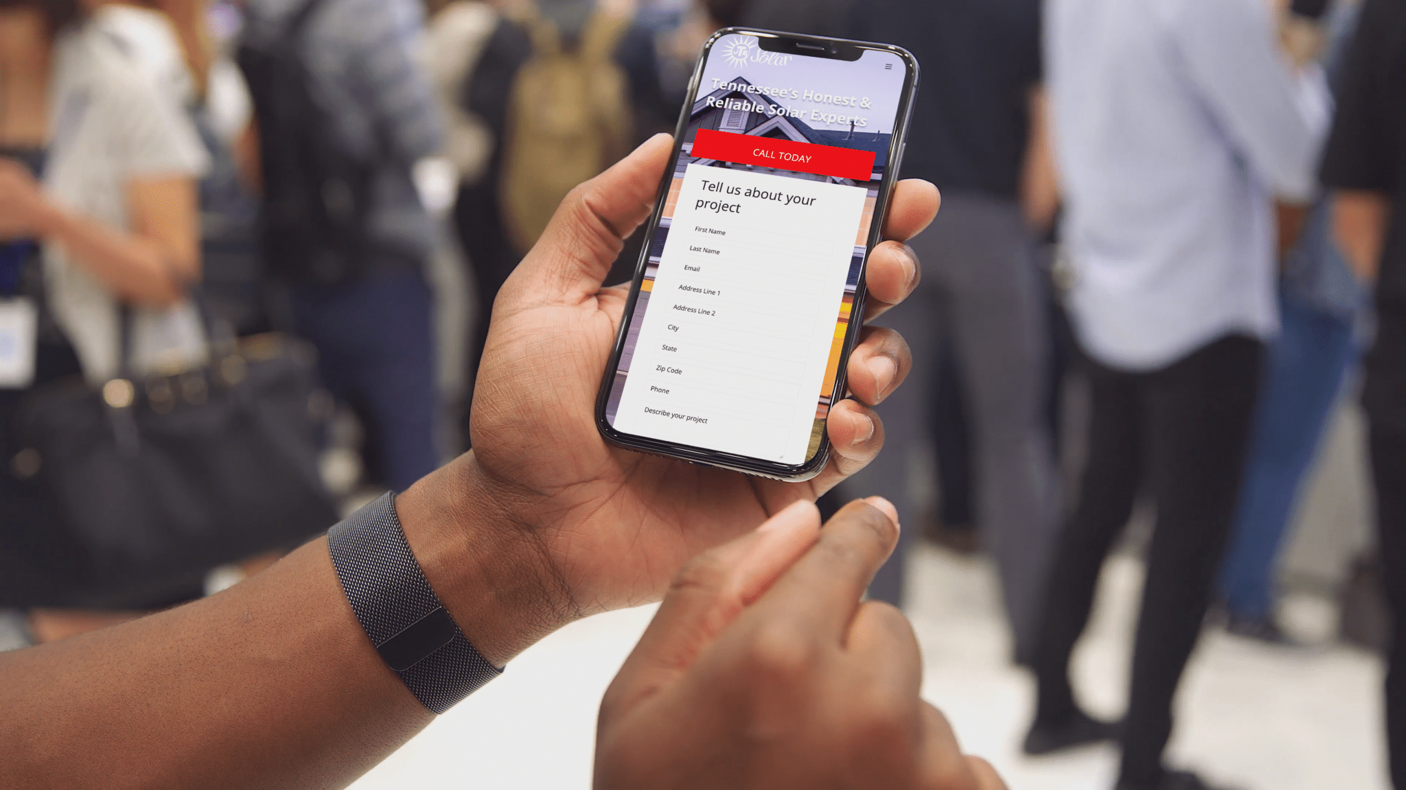 Person holds mobile phone looking at JTE Solar website.