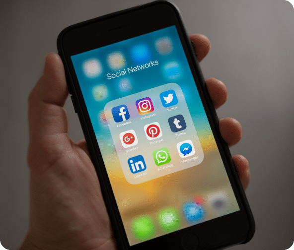 Mobile phone screen with social media apps for various social platforms.