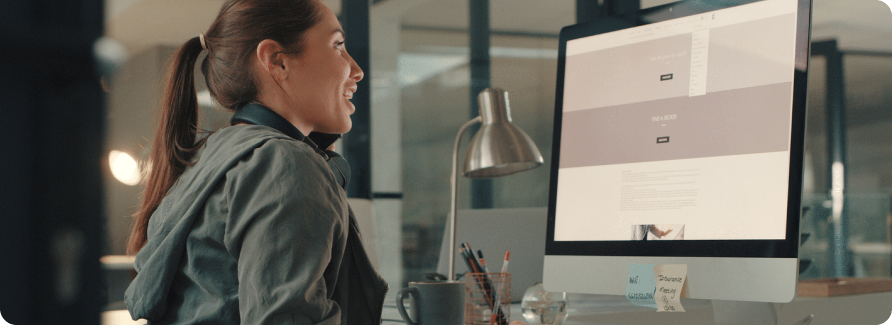 Person sits at monitor displaying the backend builder for a web page.