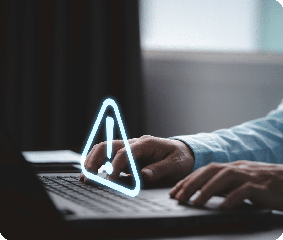 A white outline of a triangle with a white exclamation point in the middle over a keyboard.