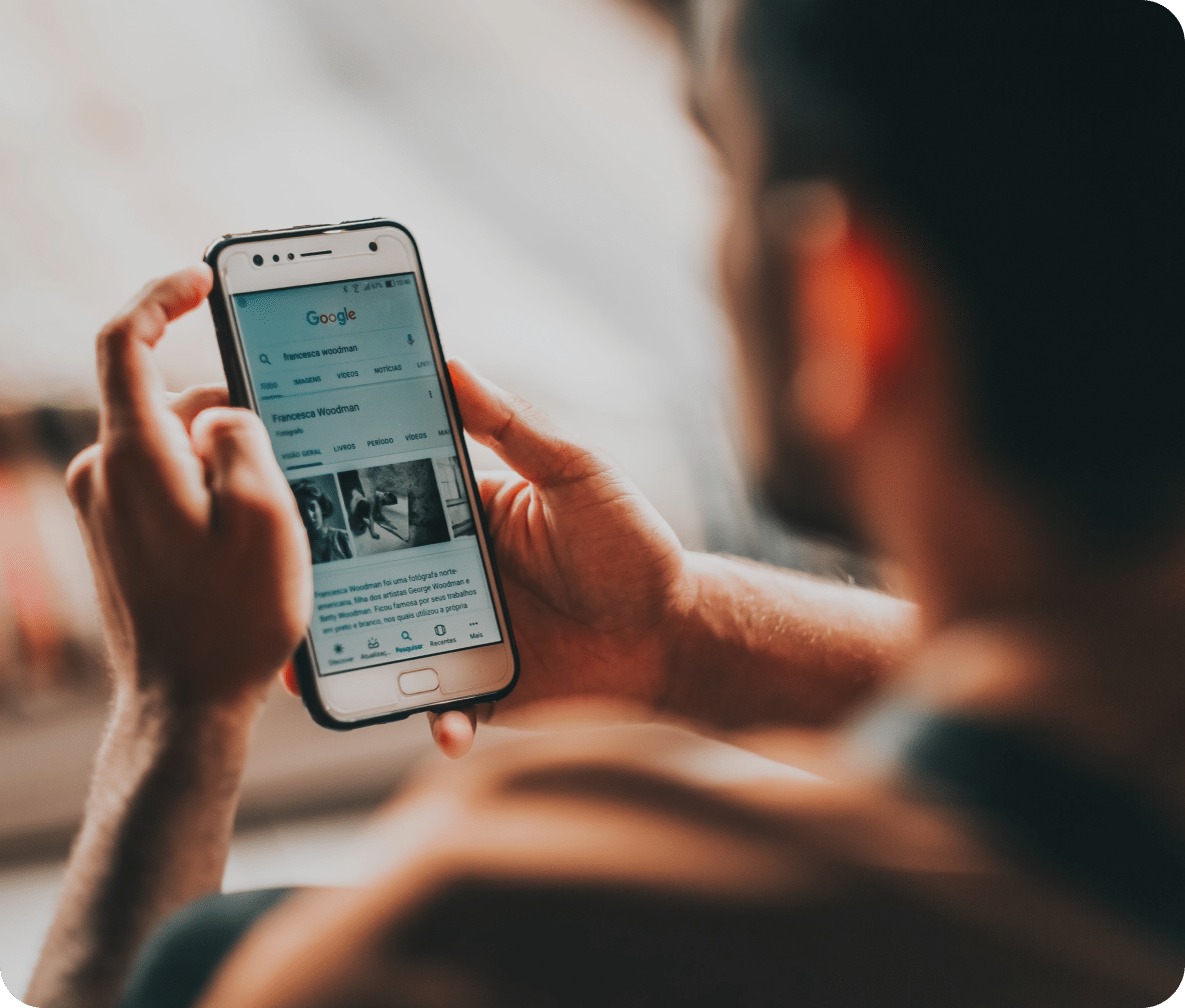 user holds their mobile phone as they search news pages.