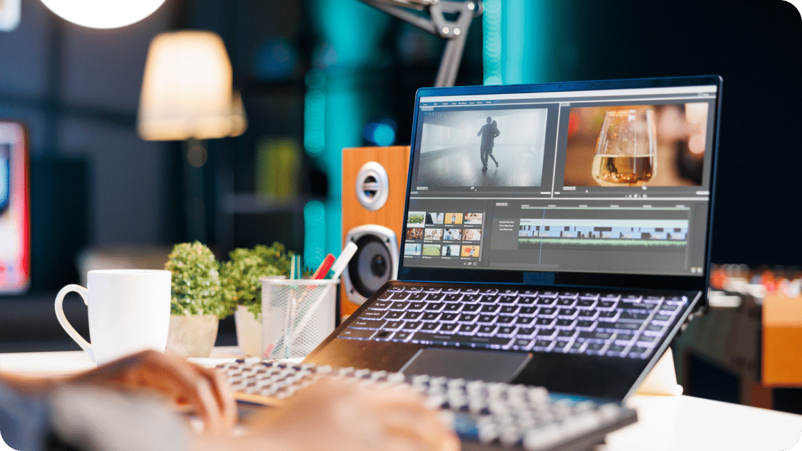 Laptop sits open, elevated on a desk with images in an editing tool visible.