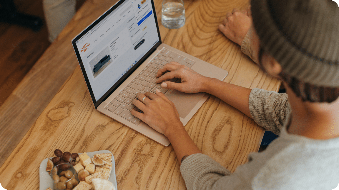 Person reviews website on a laptop sitting on a counter.