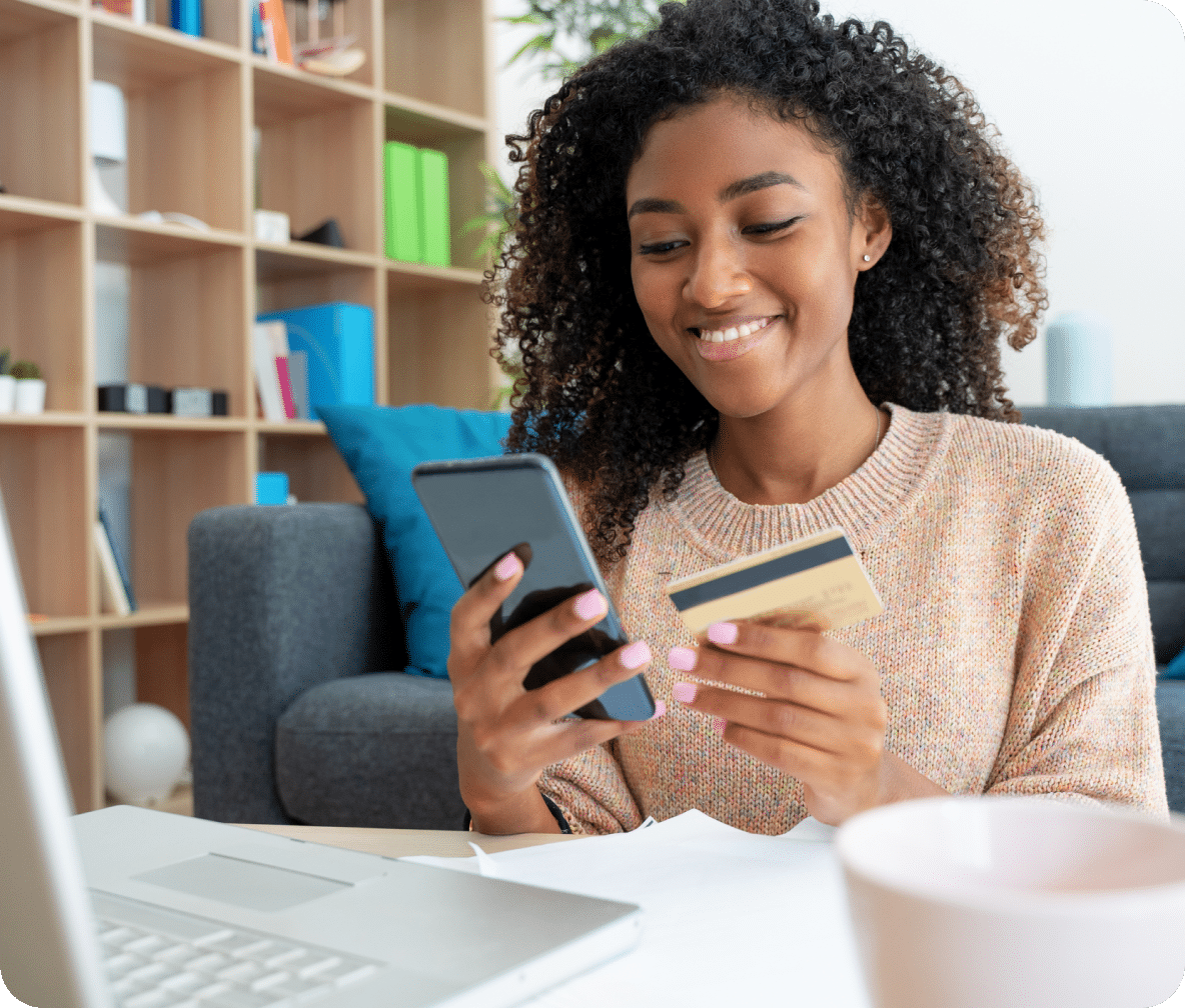 Consumer holds their mobile phone and credit card in the other.