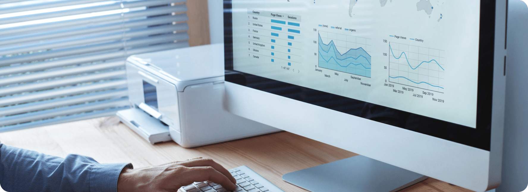 Bar graphs with line charts on the screen with hands on the keyboard.