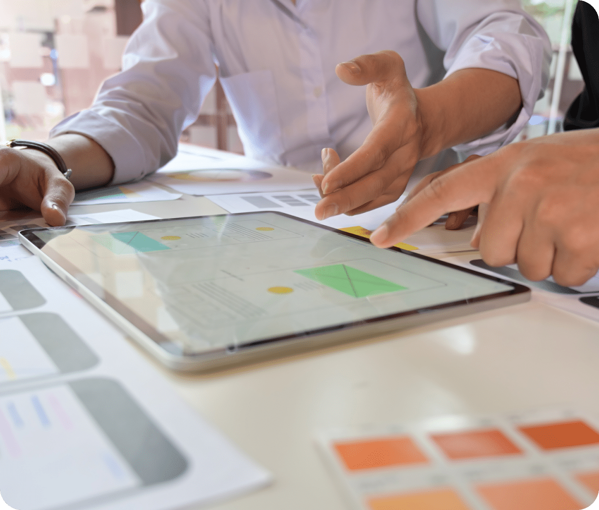 A tablet lays in front of two people looking at identification markers for location services.