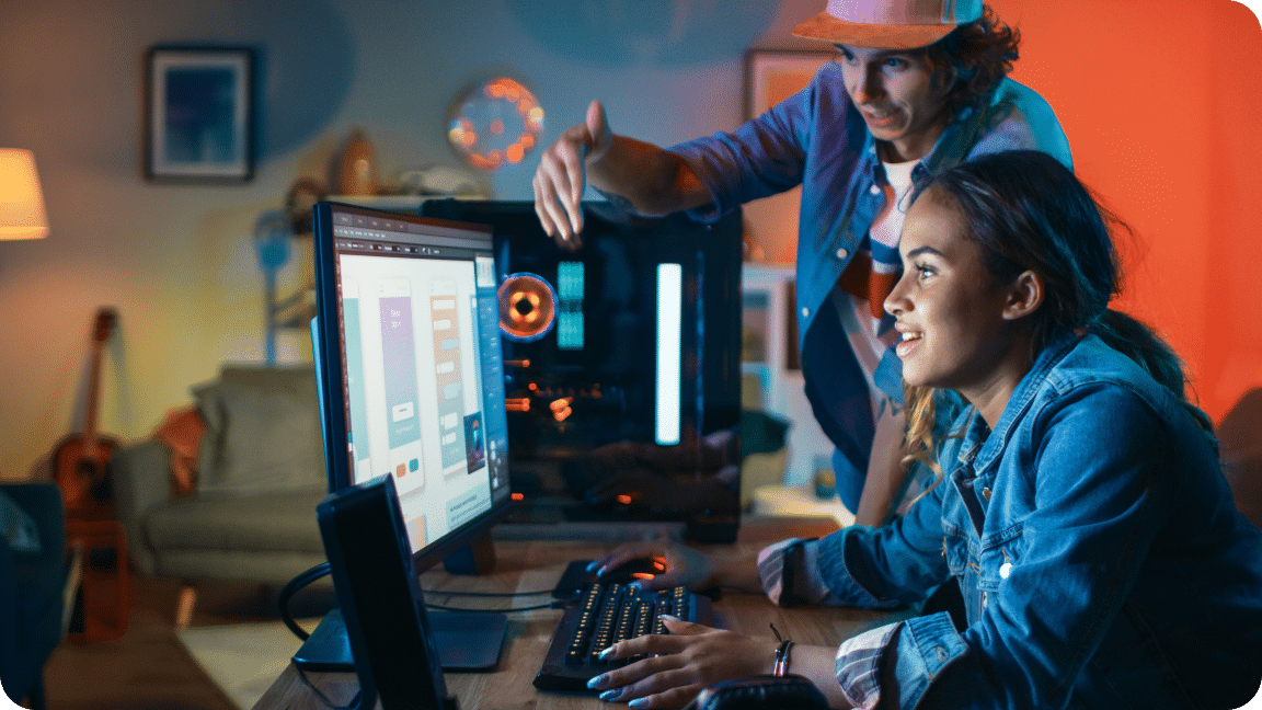 Two people look at a computer monitor screen with various data points.