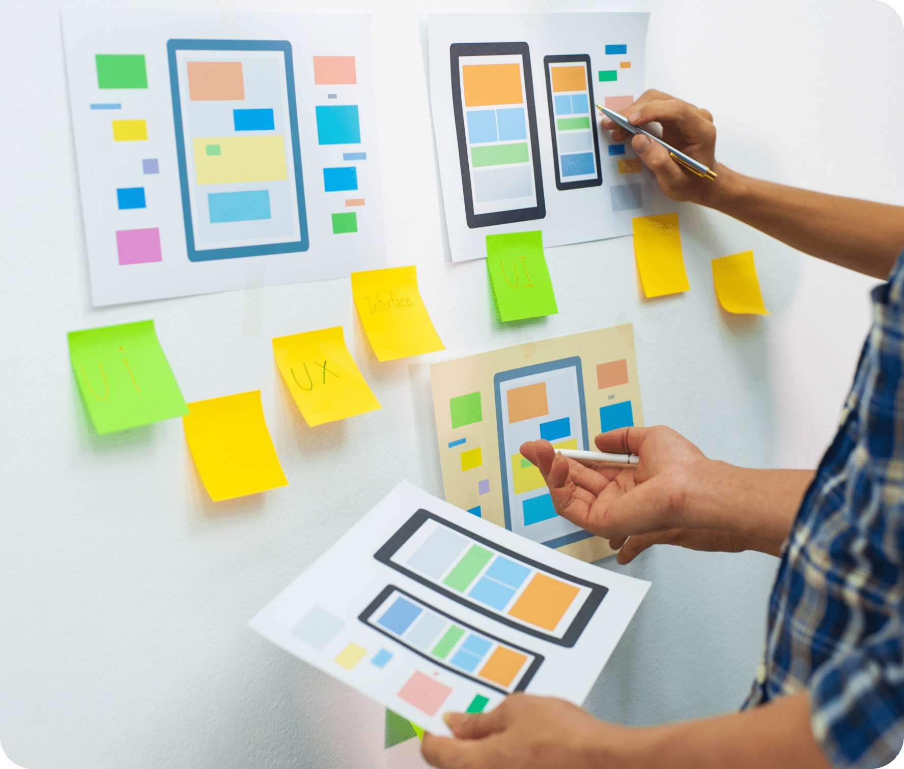 Design strategy board with various layout options, sticky notes and hands in various positions.