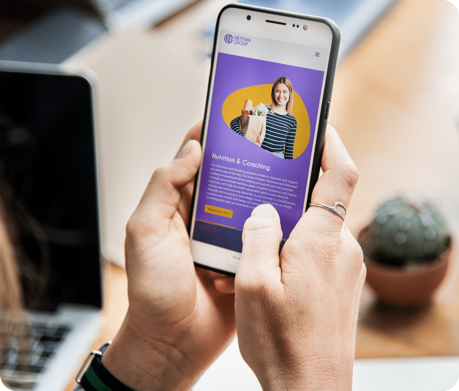 Two hands hold a mobile phone as they scroll through a website.