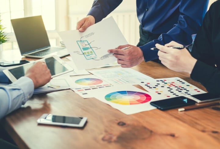 Graphic designer creative planning work together on website UX/UI development.