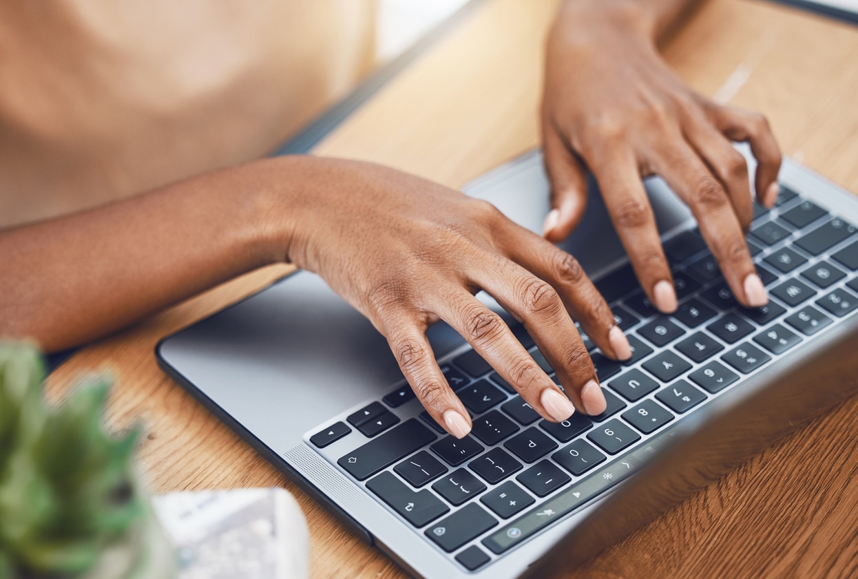 Hands using laptop keyboard for navigation.