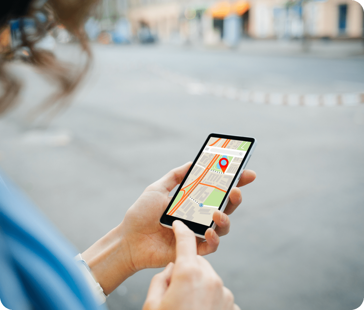 Person stands in a downtown area using their cellphone to navigate to their destination.