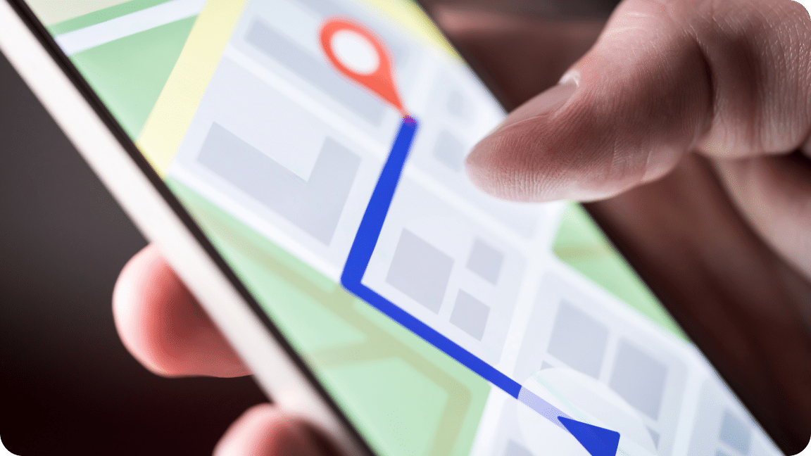 User holds their mobile phone using a location app to navigate to their location.