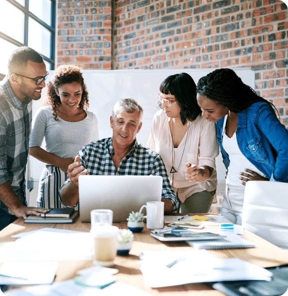 Several people gather around a laptop to offer feedback.